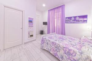 a bedroom with a bed with a purple bedspread at B&B Rest a Napoli in Naples