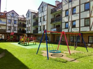 a playground in a yard in front of a building at Apartamenty Zefir in Rowy