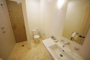 a bathroom with a sink and a toilet and a mirror at The Playhouse Hotel in Barraba