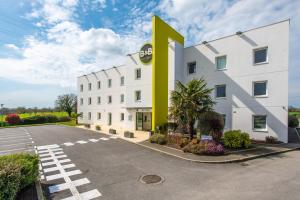 un hôtel avec une grande lettre k sur son côté dans l'établissement B&B HOTEL Vannes Ouest Golfe du Morbihan, à Vannes