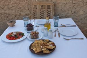 une table blanche avec des assiettes de nourriture dans l'établissement Albabenshal Lodge Siwa, à Siwa