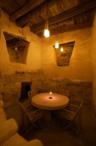 a room with a table and chairs with a candle at Albabenshal Lodge Siwa in Siwa