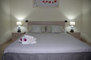 - une chambre avec un grand lit blanc et deux lampes dans l'établissement Residence La Perla, à Stalettì