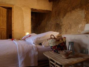 a bedroom with a bed and a table with a vase on it at Albabenshal Lodge Siwa in Siwa