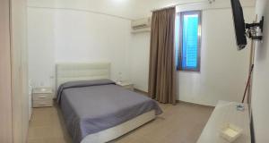 A bed or beds in a room at Porto Gaio Accomodation