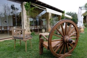 ein hölzernes Wagenrad und ein Stuhl vor einem Haus in der Unterkunft Agriturismo Calamate in Gallipoli