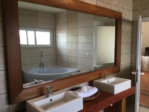 a bathroom with two sinks and a tub and a mirror at Sahamalaza in Ivato