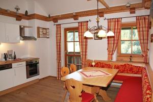 a kitchen and living room with a table and a couch at Appartement Pilzhof in Filzmoos