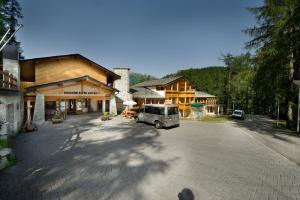 a van parked in a parking lot in front of a building at Boscone Suite Hotel in Madesimo