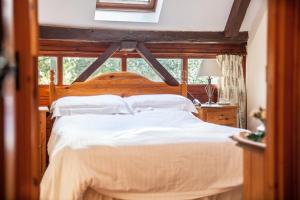 a bedroom with a wooden bed with white sheets and pillows at The Grove Cromer in Cromer