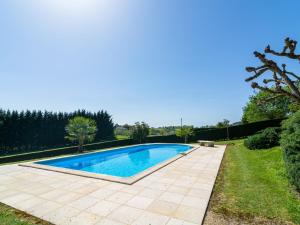 a swimming pool in a garden with a lawn at Beautiful holiday home with nature views in Villefranche-du-Périgord