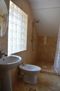 a bathroom with a sink and a toilet and a window at Casa UILA in Orşova +40 photos