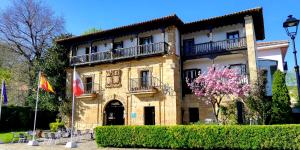 a large building with a large clock on the front of it at Hotel Museo Los Infantes in Santillana del Mar