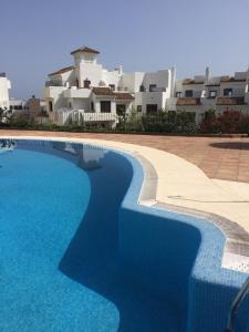 a swimming pool in front of a building at Golf Beach and Relax Townhouse in La Alcaidesa