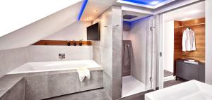 ein Badezimmer mit Waschbecken und Badewanne in der Unterkunft Boutique Suites and Residences Heidelberg- Alte Zigarrenmanufaktur in Heidelberg