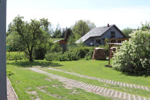 a garden with a stone path in front of a house at Apartmán Nelinka in Rudná pod Pradědem