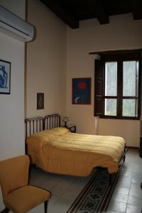 sypialnia z łóżkiem, krzesłem i oknem w obiekcie Agriturismo Malena w mieście Rossano