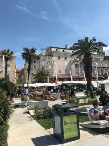 Un groupe de personnes assises sur des bancs dans un parc dans l'établissement Apartments Lana Spalato, à Split