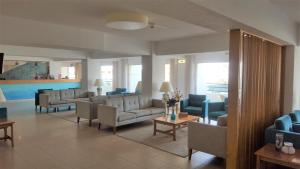a living room with couches and tables and chairs at Ourabay Hotel Apartamento - Art & Holidays in Albufeira