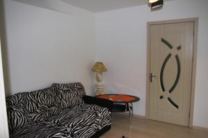 a living room with a zebra print couch and a door at Butas Prie Nemuno in Druskininkai