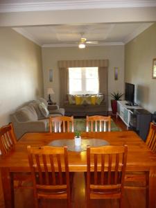 a living room with a wooden table and chairs at Shepp Central Apartment in Shepparton