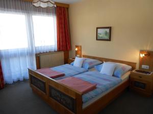 sypialnia z dużym łóżkiem z niebieską pościelą w obiekcie Pension Thorerhof w mieście Haus im Ennstal