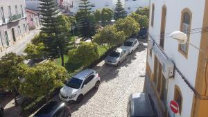 two cars parked in a parking lot next to a building at Vacaciones en el paraíso in Lagoa