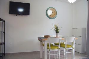プエルト・デ・ラ・クルスにあるCéntrico Apartamento con Balcón cerca de la Playaのダイニングルームテーブル(椅子付)、壁掛け時計