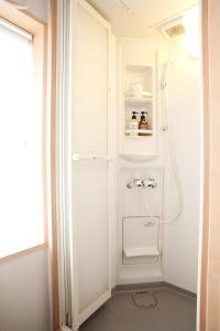 uma casa de banho com um chuveiro e um WC. em Hostel Kay 101&102 em Osaka