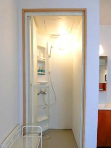 uma casa de banho com um chuveiro e uma porta de vidro em Hostel Kay 101&102 em Osaka