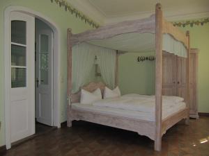a bedroom with a canopy bed with white pillows at Fledermausschloss in Lohsa
