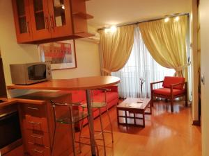 kuchnia i salon ze stołem i krzesłami w obiekcie Andes Suites w mieście Santiago