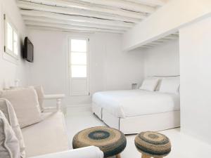 a white bedroom with a bed and a couch at Villa Kampani Sea View Villa Mykonos Town in Mikonos
