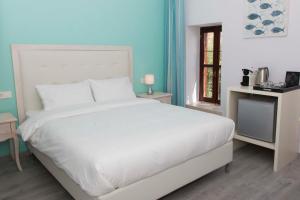 a bedroom with a white bed and a window at Shalom Luxury Rooms Kondilaki in Chania