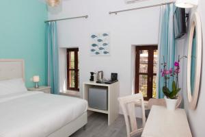 una camera con letto, tavolo e scrivania di Shalom Luxury Rooms Kondilaki a Chania