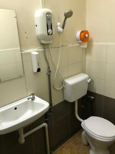 a bathroom with a toilet and a sink at Rasa Motel in Batu Ferringhi