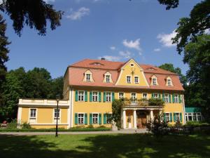 a large yellow house with a red roof at Fledermausschloss in Lohsa