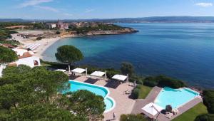an aerial view of a resort with a swimming pool and a beach at Hotel Punta Negra in Alghero