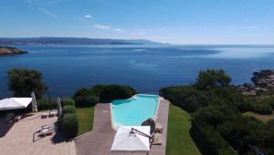an aerial view of a swimming pool and the ocean at Hotel Punta Negra in Alghero