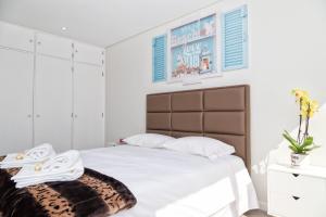 una camera con letto bianco e testiera marrone di BestVillas Âncora Mar a Vila Praia de Âncora