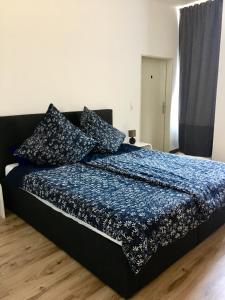 a bedroom with a bed with a blue comforter at Connie's House Holiday Apartment in Heidelberg