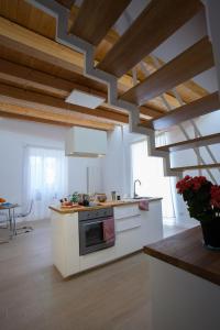 Il Sonno dei Giusti Apartment by DomuSicily في باليرمو: مطبخ مع أجهزة بيضاء وسقوف خشبية