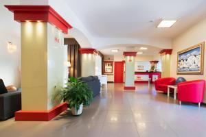un vestíbulo de un hospital con sillas rojas y azules en Hotel Mediterraneo, en Villa Cortese