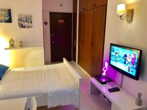 1 dormitorio con 1 cama y TV en un escritorio en Apartamento Praia do Alvor, en Alvor
