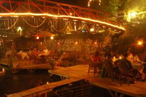 a restaurant with people sitting at tables and lights at Arikanda River Garden Hotel in Adrasan +37 photos