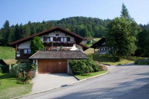 a house with a garage in front of a driveway at Haus Christl Reit im Winkl, Kostenloser Parkplatz, Spülmaschine, 5 Minuten zum Ortszentrum, ruhige Lage, Wlan in Reit im Winkl