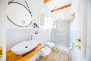 a white bathroom with a sink and a toilet at Dafni e Naide in Cefalù