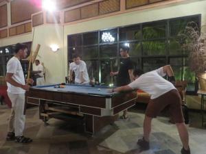 a group of people standing around a pool table at Toraja Heritage Hotel in Rantepao