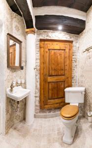 La salle de bains est pourvue de toilettes, d'un lavabo et d'une porte en bois. dans l'établissement Reinhold Apartments, à Rakvere