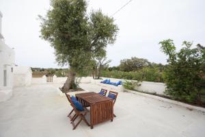 une table et des chaises sur une terrasse avec un arbre dans l'établissement A casa di Flò, à Monopoli